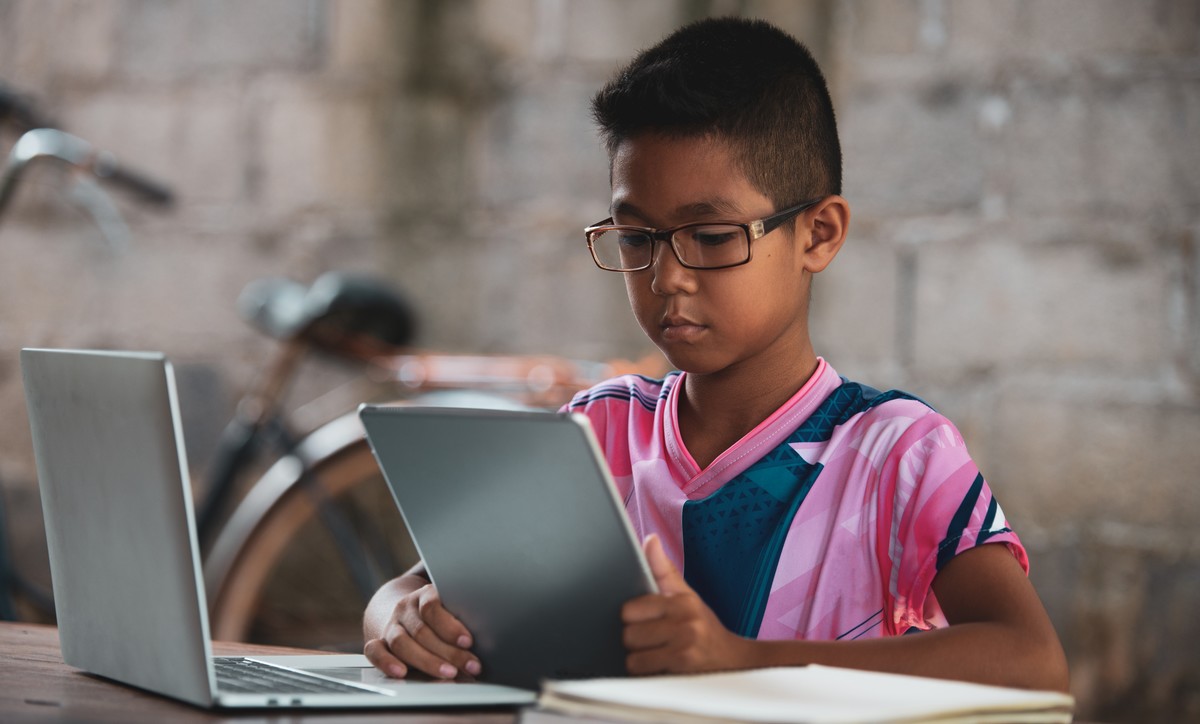 Asian boy using laptop on the table,come back to shcool